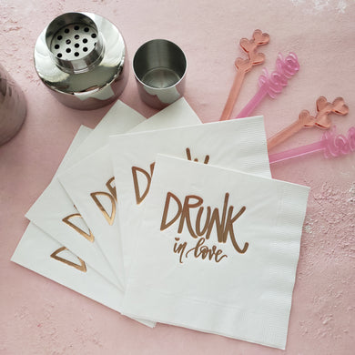 white paper napkins with drunk in love stamped in rose gold foil