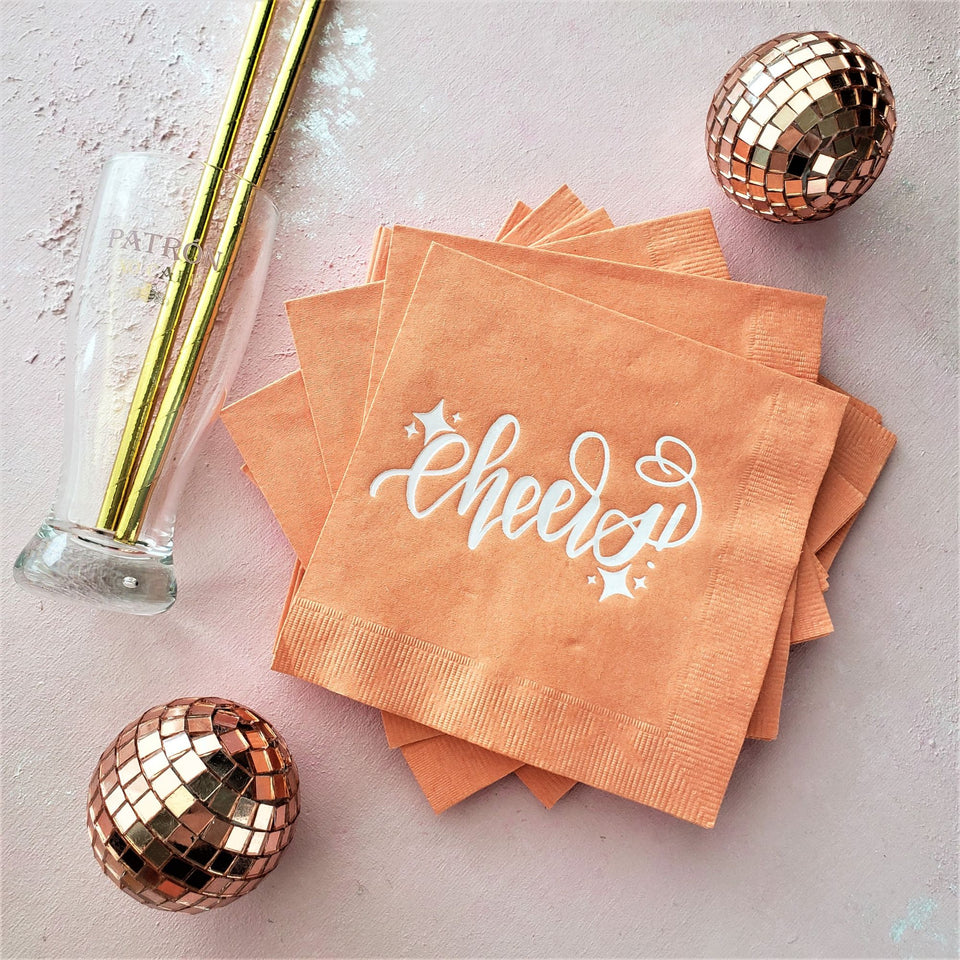 orange cocktail napkins with cheers in white foil calligraphy 