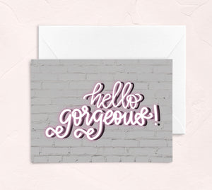galentines day greeting card - hello gorgeous pink neon sign on a white wall background