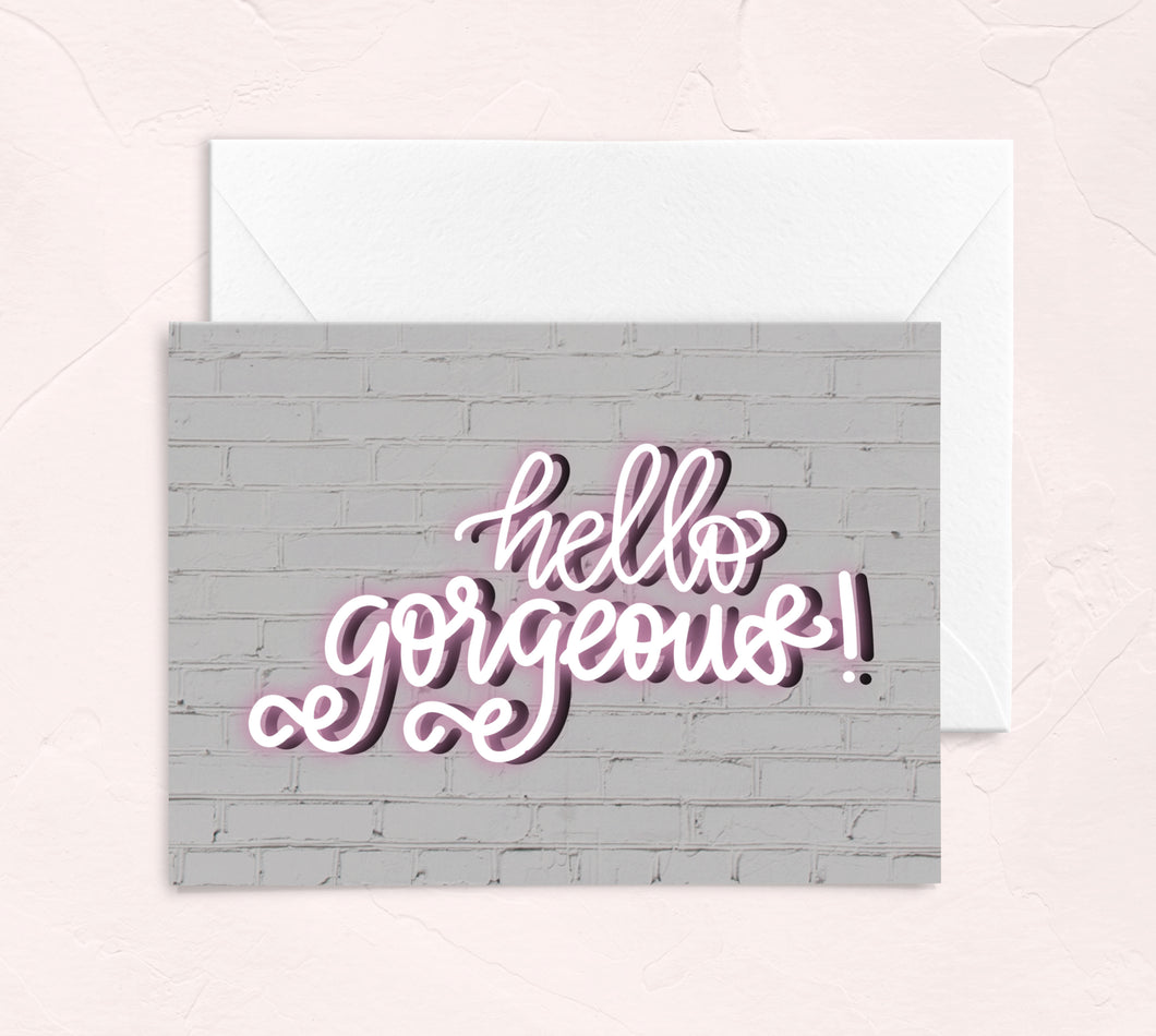 galentines day greeting card - hello gorgeous pink neon sign on a white wall background