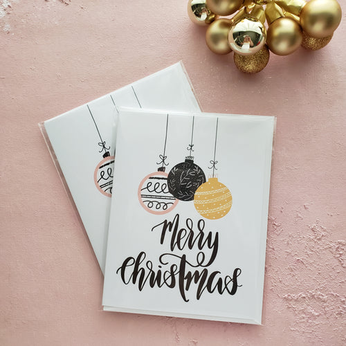 modern calligraphy merry christmas greeting card with christmas ornaments by fioribelle